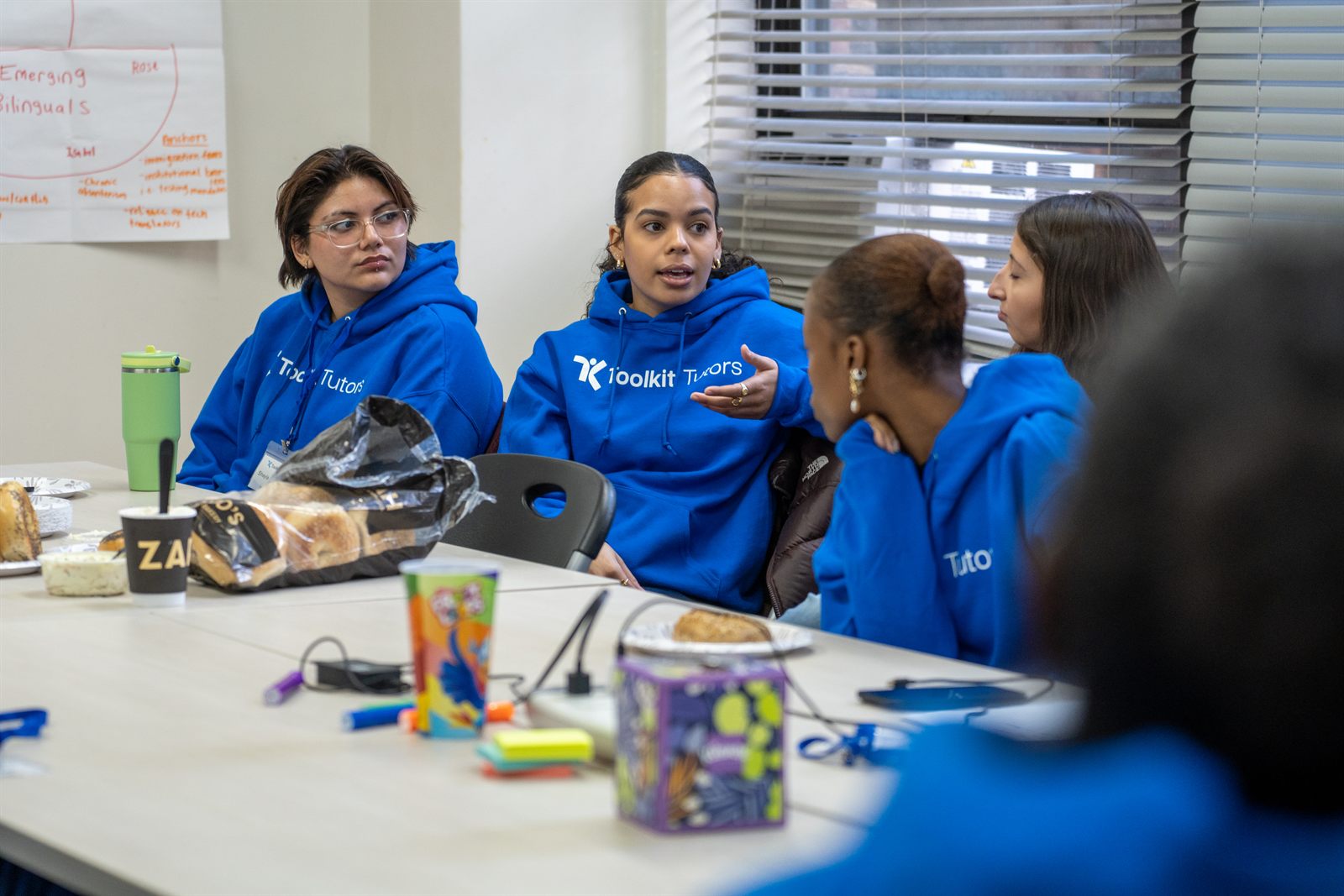 Toolkit Tutors team members meeting in branded blue hoodies